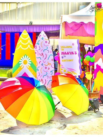 The entrance to the party featured colourful surfboard props and rainbow umbrellas, immediately setting a fun, summery, and beachy vibe.