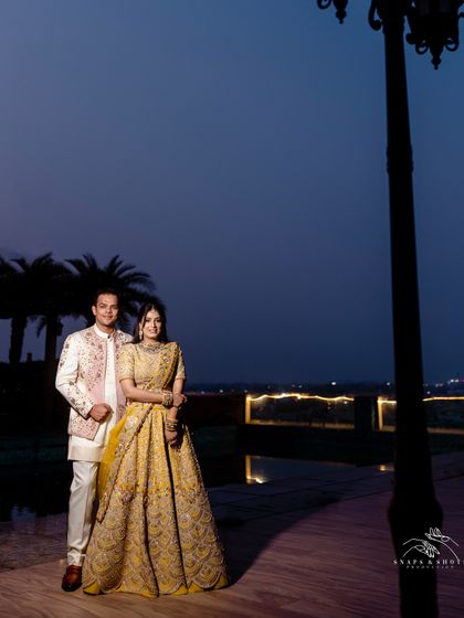 A wide shot showing the couple's outfits in the context of their beautiful outdoor engagement venue. The colors we chose for them stand out beautifully against the evening backdrop.