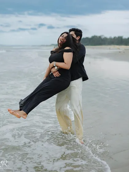 A playful lift in the shallow waters of the Goan sea. This shot is full of fun and laughter, showcasing the carefree spirit of their relationship during this beach session.