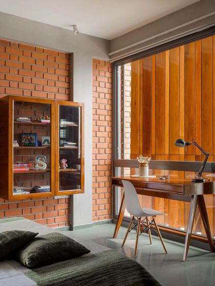 In the bedroom, the wooden screen filters the afternoon sun, casting soft light across the study desk. This feature demonstrates how we use architectural elements to create comfortable and functional interior environments.