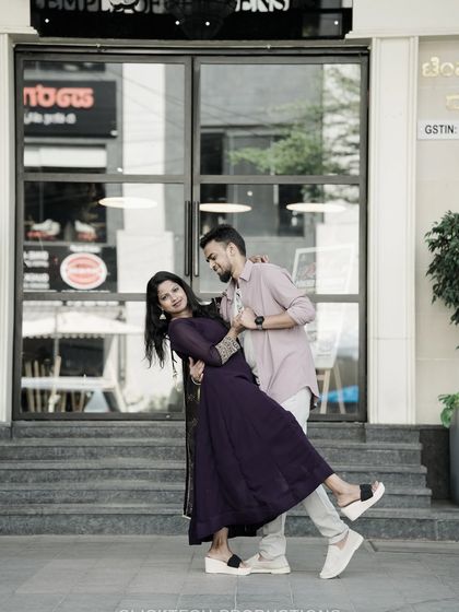 A playful dip pose in front of a modern storefront, capturing the couple's fun-loving energy in an urban environment.