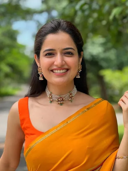It was such a pleasure to design for the gorgeous actress Ashika Ranganath. I created this simple yet vibrant orange sleeveless blouse to perfectly complement her colorful saree.