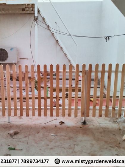 A wooden picket fence before painting, showing the natural wood grain. We can provide fences in both natural and painted finishes.