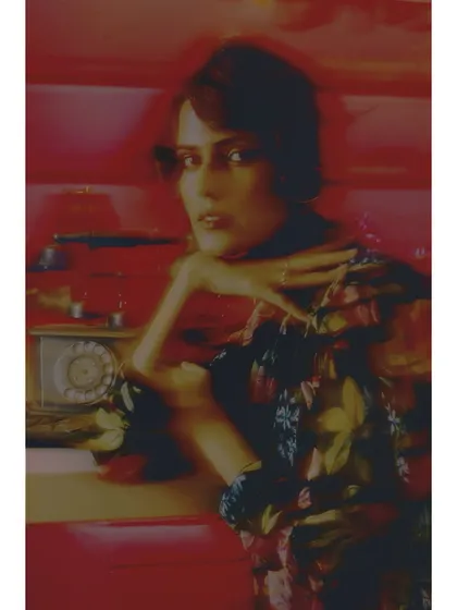 A soft-focus shot capturing the heroine in a moment of thought. The blur effect and warm tones enhance the dreamlike, nostalgic quality of the scene.