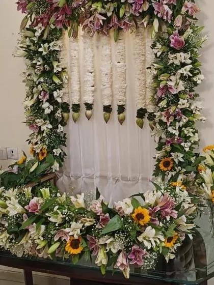 The complete Ganpati pooja setup with the lily and sunflower floral frame, creating a stunning focal point for worship.