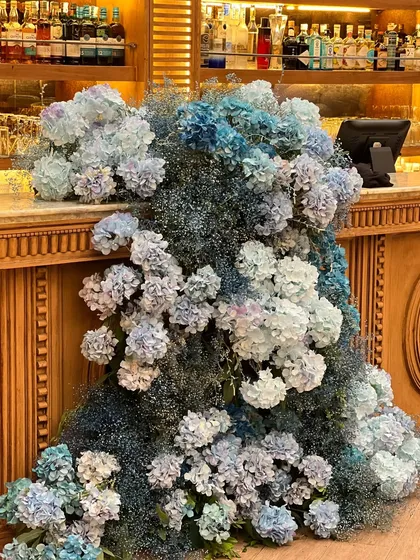 The theme was carried through with a magnificent floral installation of blue hydrangeas on the bar and a large, backlit giraffe cutout that added a touch of modern whimsy.