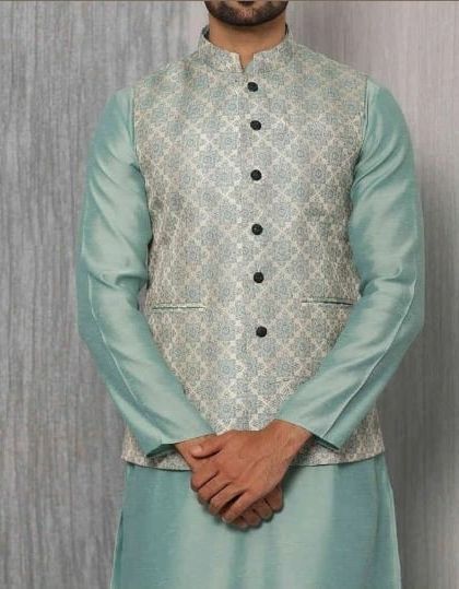 A beautiful jacquard Nehru jacket with a subtle pattern, worn over a light green silk kurta. This showcases a sophisticated and understated ethnic style.