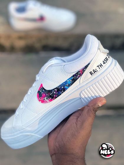 A hand-held shot of the galaxy swoosh sneaker, showing the personalized text on the heel.