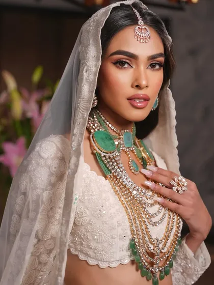 A stunning portrait of the bride in white. The makeup is soft and ethereal, with a focus on the eyes.