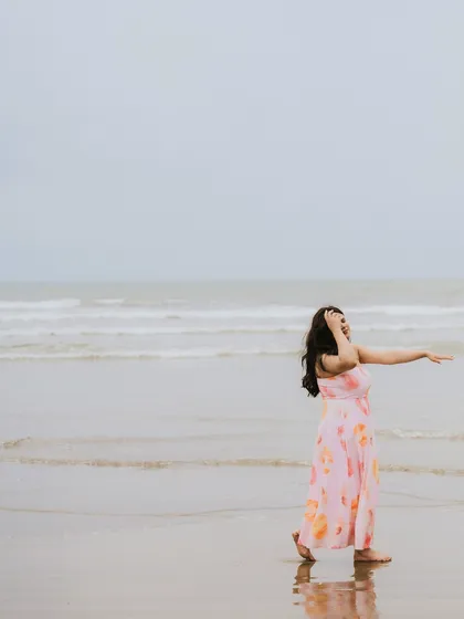 A beautiful shot of the bride-to-be walking along the shoreline, her dress catching the sea breeze.