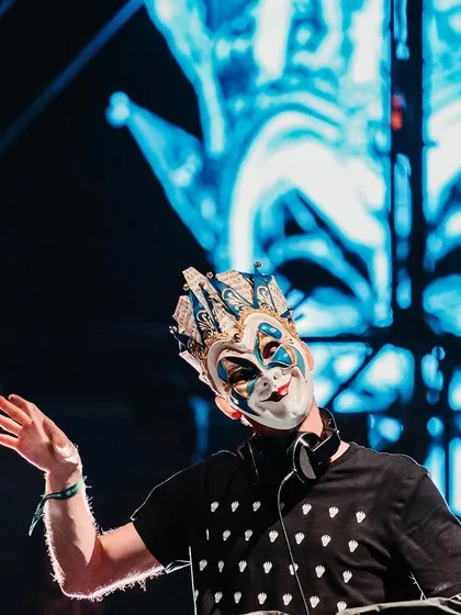 Another angle of Boris Brejcha's performance, with his mask highlighted against a blue visual backdrop.