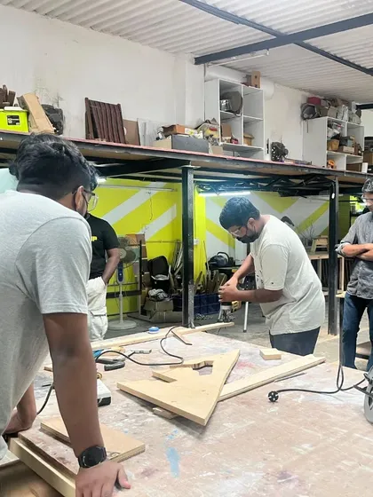 Learning happens together here. This shot captures a typical weekend workshop where our instructor guides a group of new makers through the fundamentals of woodworking, ensuring everyone is comfortable and safe before they start their own projects.