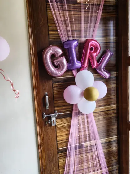 A simple yet charming door decoration announcing 'GIRL'. I used foil letters, a small balloon flower, and pink netting.