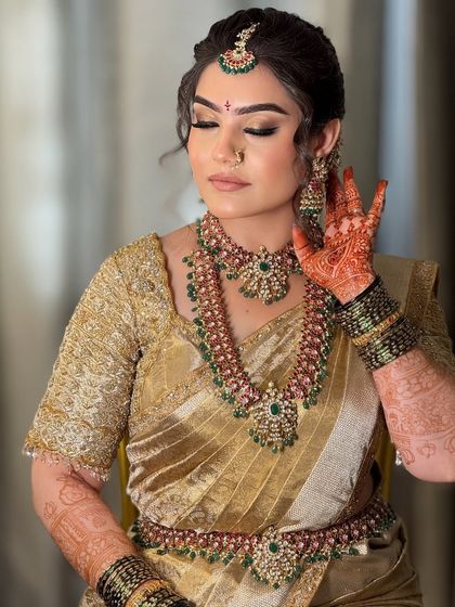 A candid moment showing the bride's intricate henna and how the makeup complements the overall traditional aesthetic.