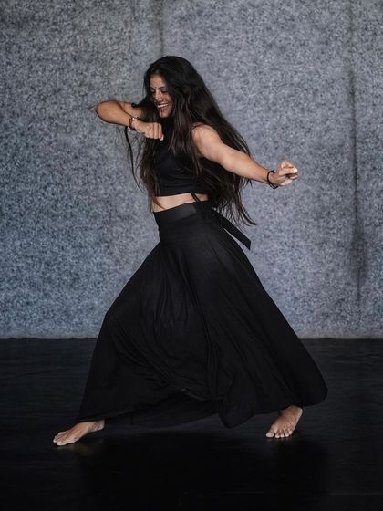 A powerful, grounded stance from an Indian Contemporary routine. This form of dance builds strength, flexibility, and expressive capability.