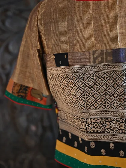 A detailed close-up of the blouse's back, where you can appreciate the intricate weave of the Banarsi silk and the colorful patchwork trim on the sleeves.
