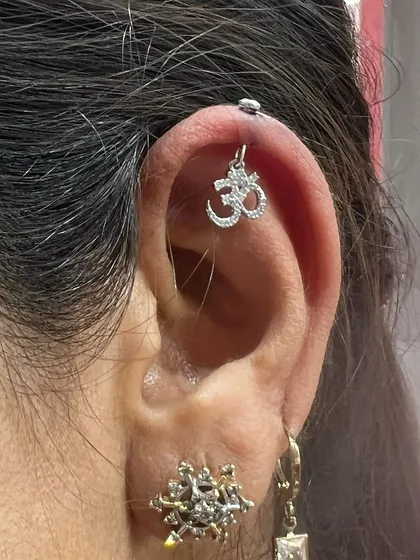 An Om hanging from the helix is a popular choice for those who want to combine their spirituality with their style.