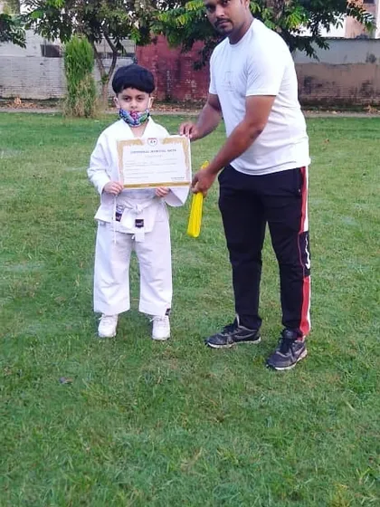 Awarding a certificate to one of our youngest students after an outdoor belt grading test. We train in different environments to keep things interesting.