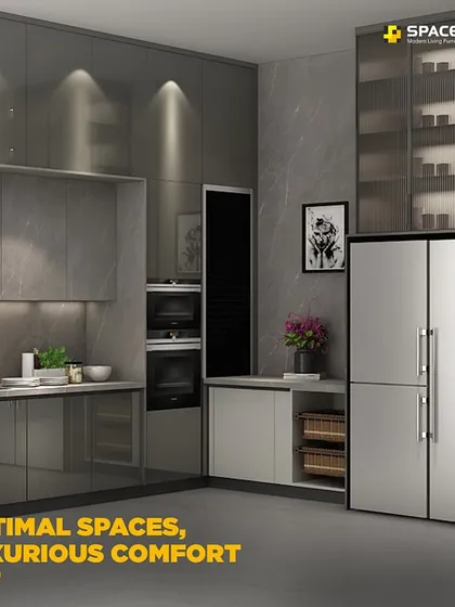 This L-shaped modern kitchen is designed for optimal workflow and luxurious comfort. It features sleek grey cabinets, integrated double ovens, and a combination of open and closed storage, including glass-fronted display cabinets.