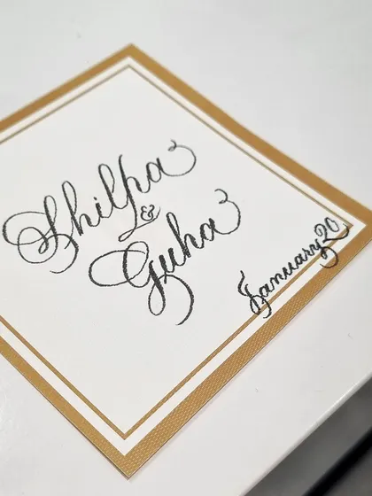 Personalizing a card with the names of a couple. This kind of custom calligraphy is a popular request at live events, turning a simple card into a cherished keepsake.