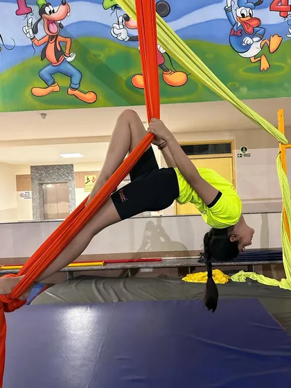 A deep backbend pose, or "bridge," performed on the silks, which helps to open the chest and shoulders while building strength.