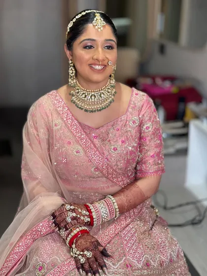 My lovely bride Nilomi in a beautiful pastel pink lehenga. Her makeup is soft and romantic, with a focus on rosy cheeks and gently defined eyes.