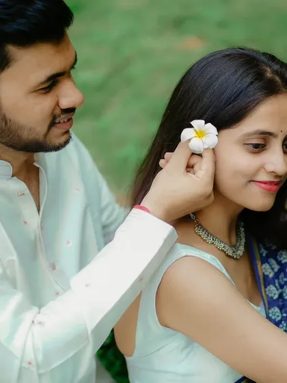 A sweet, gentle moment. Umesh places a flower in Janhavi's hair, a simple gesture of love captured during their traditional pre-wedding shoot.