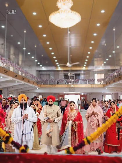 The couple during the Laavan Pheras, a central part of the Sikh wedding ceremony. This shot captures the movement and tradition of the moment.