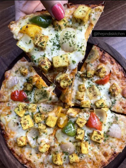 Here's a slice of my Paneer Pizza, loaded with cheese and marinated paneer tikka chunks. I use a thin, crispy base and top it with fresh bell peppers and onions, making it a cheesy, satisfying treat for all pizza lovers.