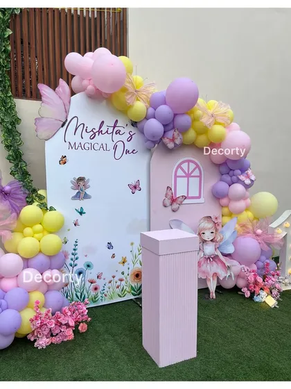 A close-up of the fairy-themed backdrop, showing the personalized "Mishita's Magical One" sign and beautiful balloon work.