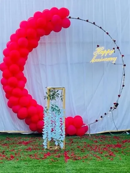 A passionate red version of the modern anniversary backdrop. The vibrant red balloon crescent makes a bold statement against the white background and green lawn.