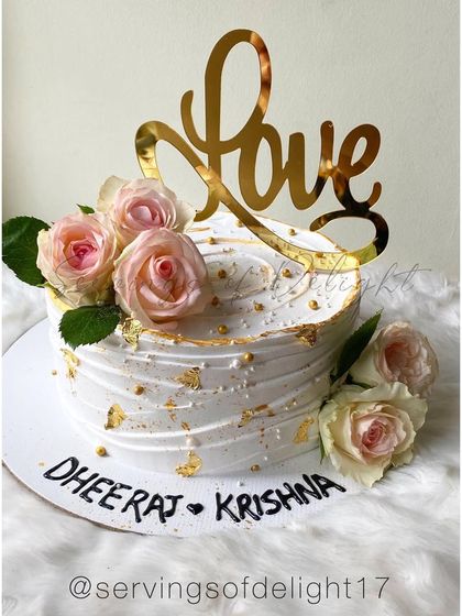 A personalized version of the fresh floral "Love" cake, with the couple's names hand-piped on the board for that extra special touch.