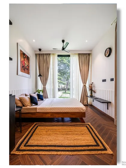 A bedroom in a prefab home with a large window that opens up to a garden view. The simple, clean design and natural materials make this a peaceful and relaxing retreat.