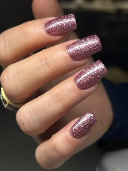 A sparkling rose-gold glitter manicure on square-shaped extensions. This warm, glittery shade is both trendy and glamorous.
