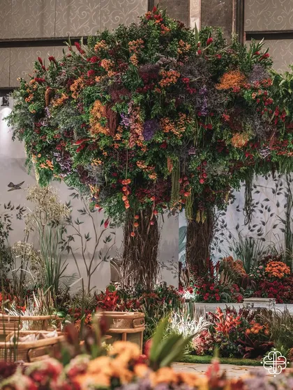 A wide view of the 'Orchard of Life' setup, showing the magnificent floral trees that define the space. The entire hall was transformed into a symbolic grove for the naming ceremony.