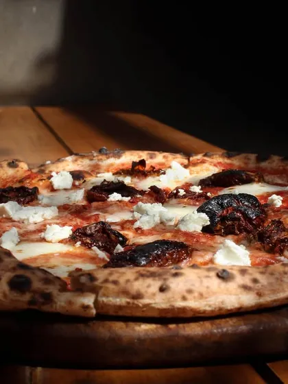 Our Smokey Marzano pizza soaking up the sun. It features a classic combination of sundried tomatoes, garlic, feta, and our hand-stretched mozzarella on a sourdough base.