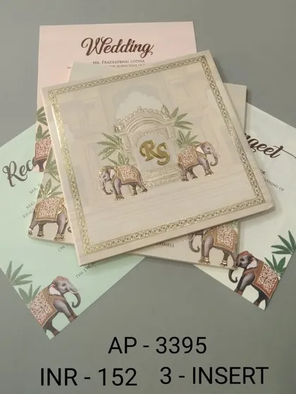 A simple yet regal invitation in a cream color, featuring two elephants and a custom 'RS' monogram. This set includes three inserts for your Reception, Sangeet, and Wedding details.