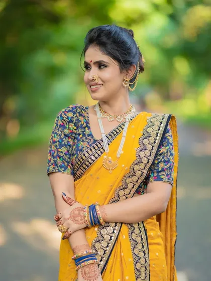 A happy bride in her element. The makeup is kept fresh and natural to complement the outdoor setting and the beautiful yellow saree.