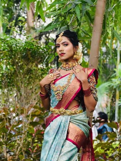 This series showcases a model in a beautiful light blue saree, adorned with a full temple jewellery set. The outdoor setting highlights the richness of the antique gold finish.