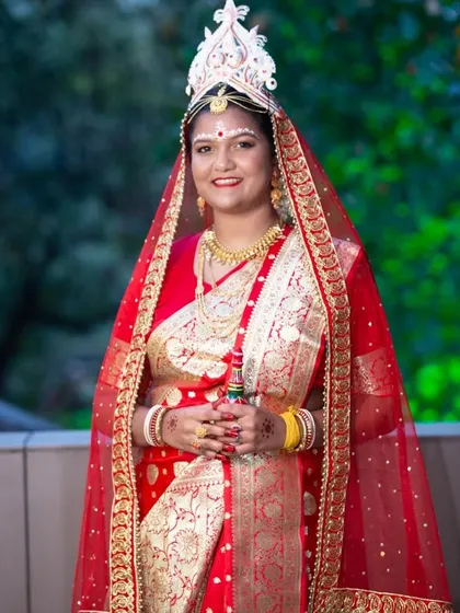 A beautiful portrait of a Bengali bride in her red wedding saree and veil, ready for her ceremony.