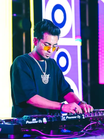 Focused on the mix at Parul University. This shot captures me on the Pioneer DJ console, blending tracks and curating the sound for a huge college fest audience.