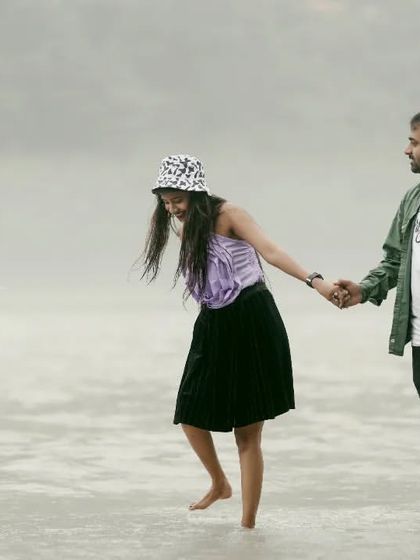 A playful moment during a riverside shoot, with the couple walking hand-in-hand in the water.