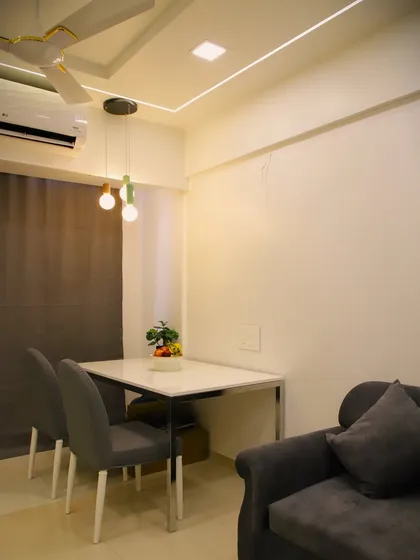 Another view of the compact dining setup, highlighting the modern pendant lights that add a touch of contemporary flair.