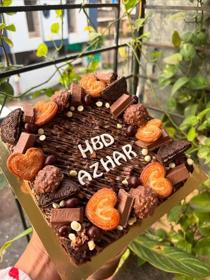My signature loaded brownie slab is a dream come true for any chocolate lover. I start with a fudgy, eggless brownie base and then load it up with an assortment of treats like KitKat bars, Oreo cookies, Ferrero Rocher, and crispy little heart biscuits. It's a fantastic and fun alternative to a traditional birthday cake.