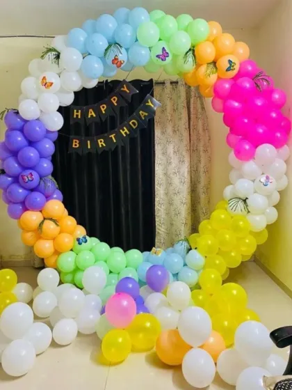 A vibrant rainbow-colored balloon ring. This cheerful decoration is perfect for any age and includes a 'Happy Birthday' banner and butterfly accents.