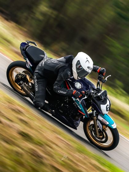 A dynamic, tilted angle shot shows Poojita AK navigating a corner with precision on her number 6 race bike. This highlights the aggressive riding style and control she developed under our coaching.