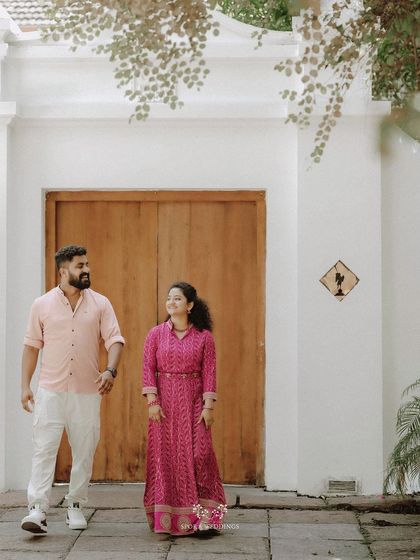The couple walking together, their coordinated pink and white outfits looking fresh and stylish.