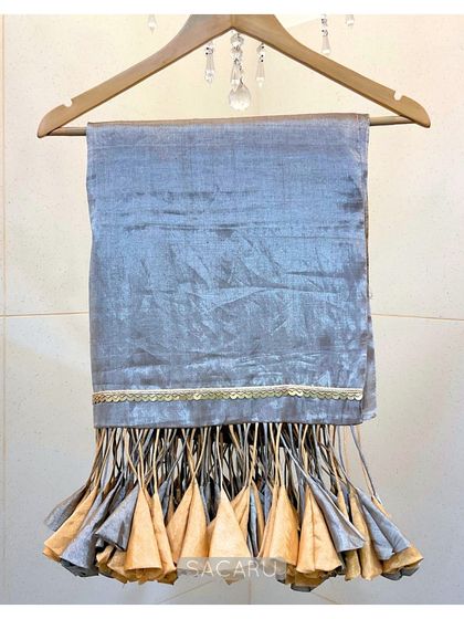 The saree's dramatic tassels on full display, showing the beautiful craftsmanship of the gold and silver fabric cones.