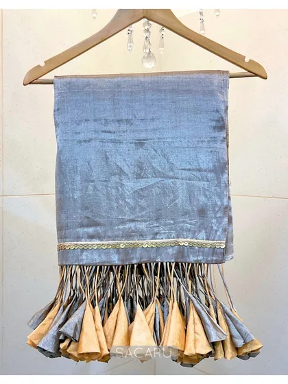 The saree's dramatic tassels on full display, showing the beautiful craftsmanship of the gold and silver fabric cones.