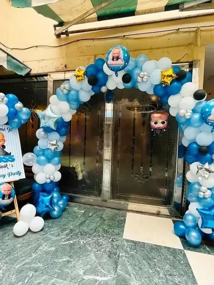 A fun entrance decoration for a "Boss Baby" themed birthday party. This setup includes a full balloon arch and character cutouts to welcome guests.